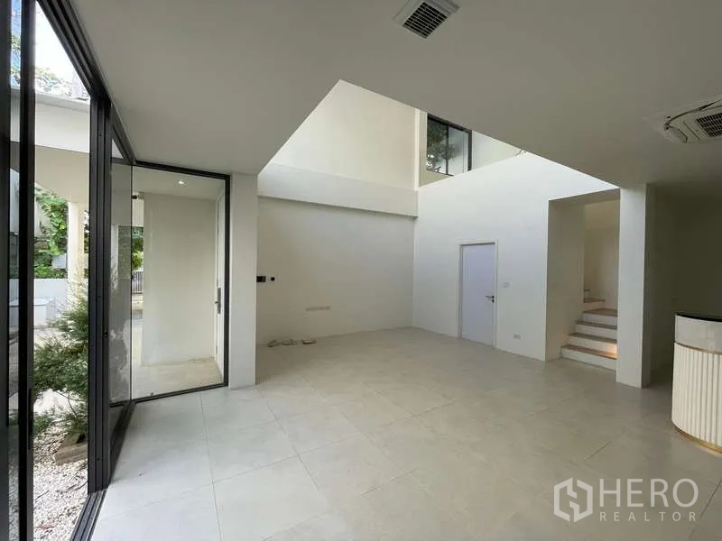 สำนักงานที่บ้าน ให้เช่าในDon Mueang, Bangkok - โถงชั้นล่างเพดานสูงสองชั้น ประตูกระจกบานเลื่อนเปิดสู่สวน