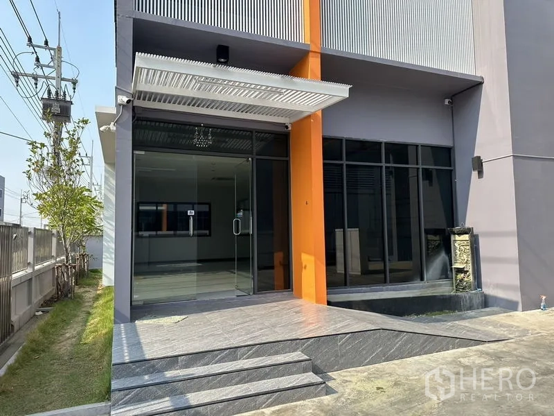 โรงงาน ให้เช่าหรือขายในLam Luk Ka, Pathum Thani - ระเบียงทางเข้าอาคารพร้อมประตูกระจก กันสาด และบันไดทางขึ้น