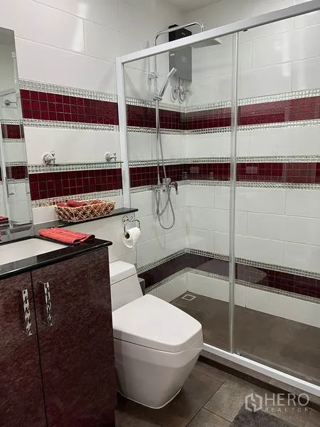 Detached House for rent in Bang Kapi, Bangkok - Contemporary bathroom with glass-enclosed shower, red mosaic tile accents and vanity.