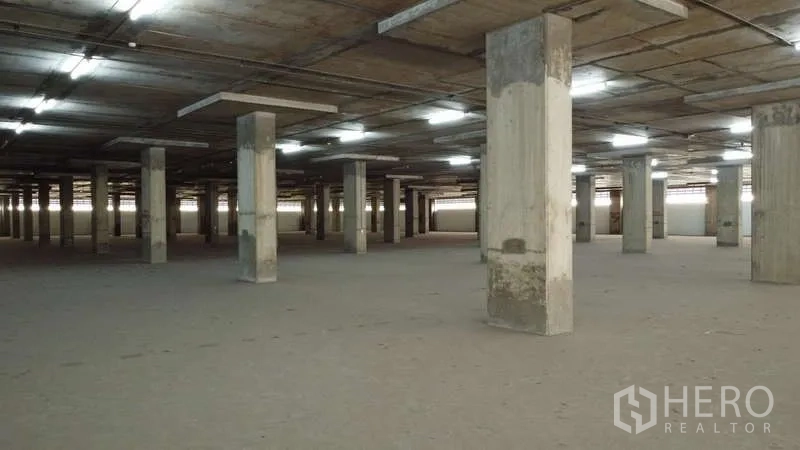 Warehouse for rent in Khlong Toei, Bangkok - Large raw warehouse floor with ventilation blocks and evenly spaced columns.