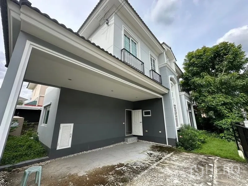 Detached House for sale in Bang Khen, Bangkok - Covered two-car carport beside the house with small lawn and driveway.