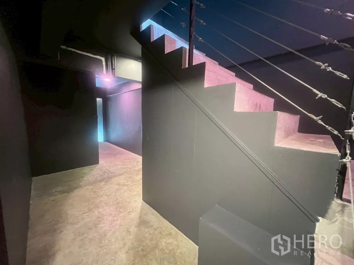 อาคารพาณิชย์ ให้เช่าในWatthana, Bangkok - บันไดภายในผนังสีเข้ม เชื่อมขึ้นชั้นบน ใต้แสงไฟสลัว.