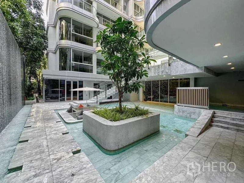 Condominium for sale in Watthana, Bangkok - Courtyard pool and water features at Q Prasarnmit with landscaped planter.