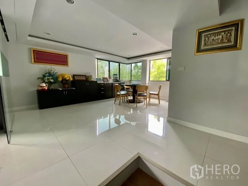 Home Office for rent or sale in Yan Nawa, Bangkok - Meeting nook with round table, corner windows, and dark cabinetry.