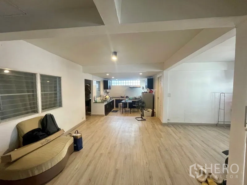 ทาวน์เฮาส์ ให้เช่าในDin Daeng, Bangkok - พื้นที่นั่งเล่นและรับประทานอาหารแบบเปิดโล่งพร้อมพื้นลายไม้ต่อเนื่องไปครัวบิวท์อิน