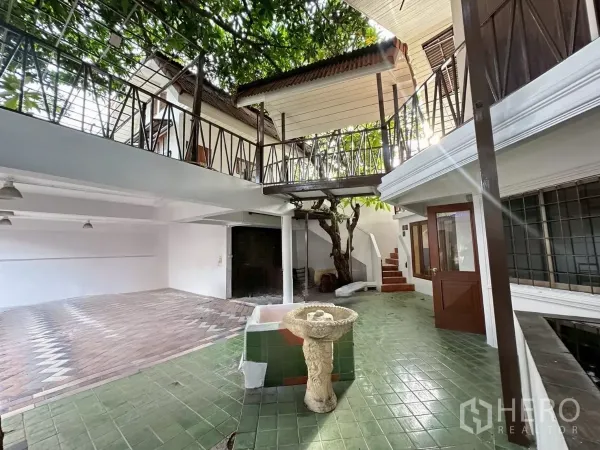 สำนักงานที่บ้าน ให้เช่าในLat Phrao, Bangkok - ลานกึ่งเปิดโล่งปูพื้นกระเบื้องสีเขียว พร้อมทางเดินระเบียงและต้นไม้ใหญ่