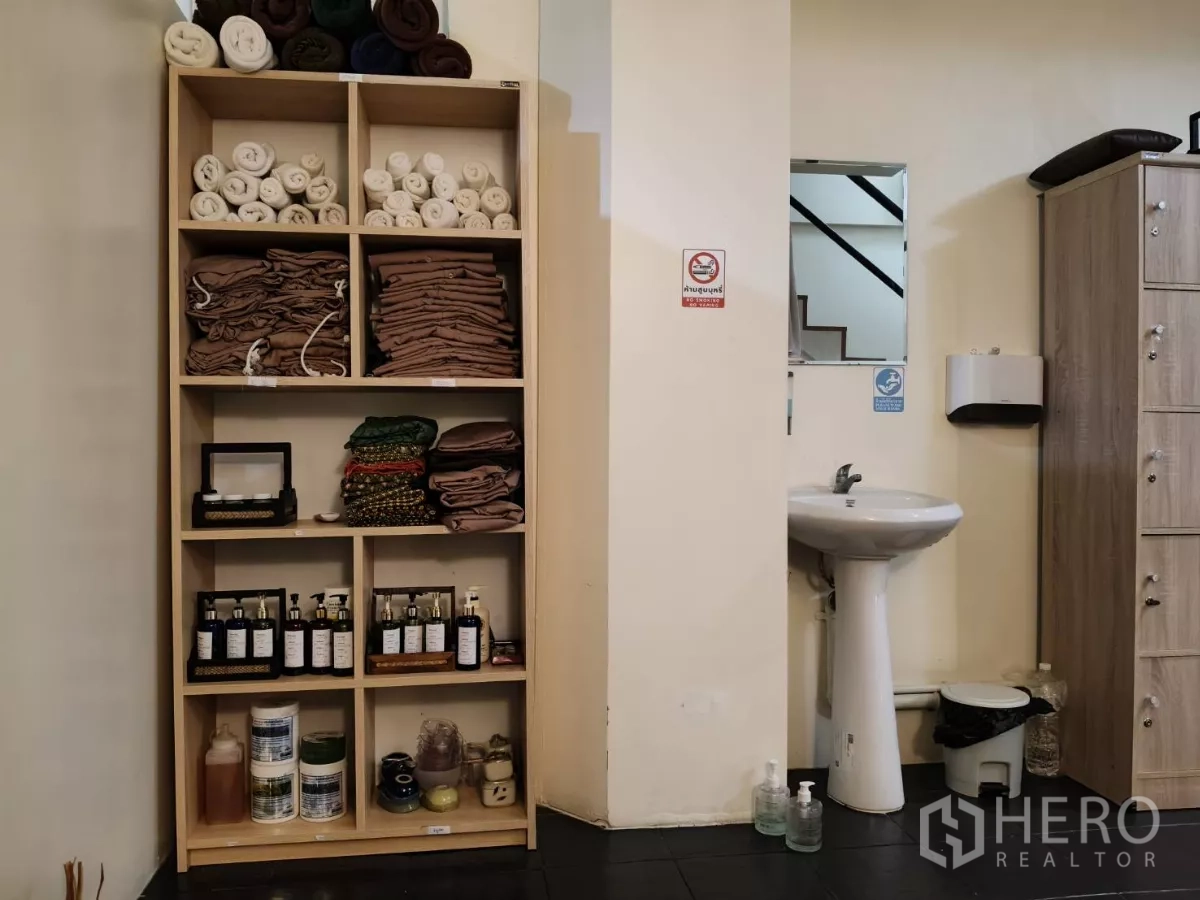 店屋 出租在Watthana, Bangkok - 开放式置物架摆放毛巾、浴袍与精油，旁有立式洗手盆。