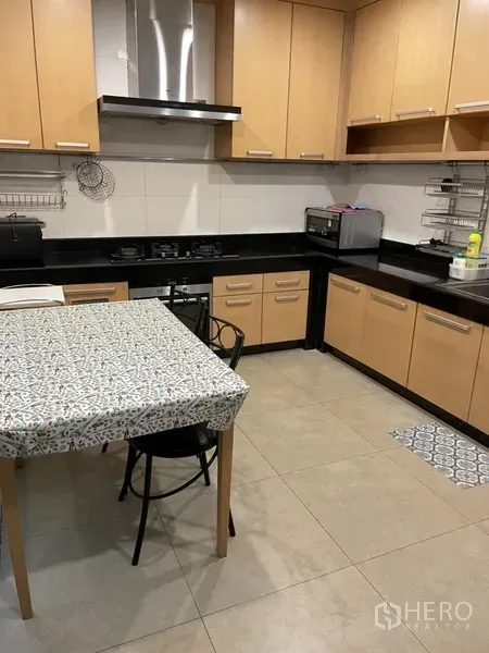 Home Office for rent or sale in Phra Khanong, Bangkok - L-shaped kitchen with light wood cabinetry, black countertops and a gas hob.