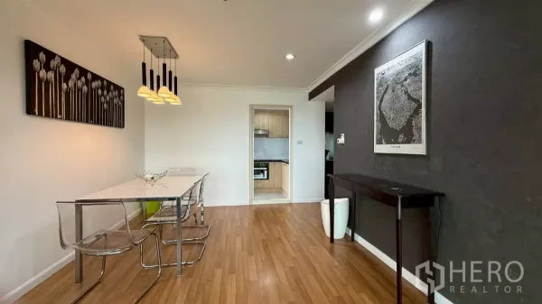 คอนโด ขายในYan Nawa, Bangkok - มุมรับประทานอาหาร โต๊ะสีขาว เก้าอี้ใส โคมไฟแขวน และทางเข้าครัว