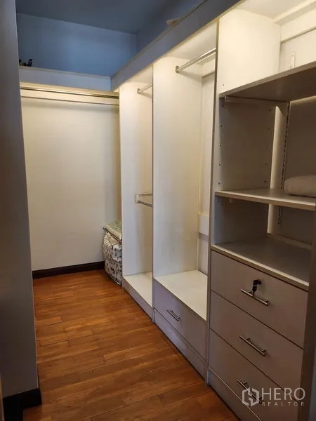 Detached House for rent in Bang Kapi, Bangkok - Walk-in closet with white built-in wardrobes and wooden flooring.