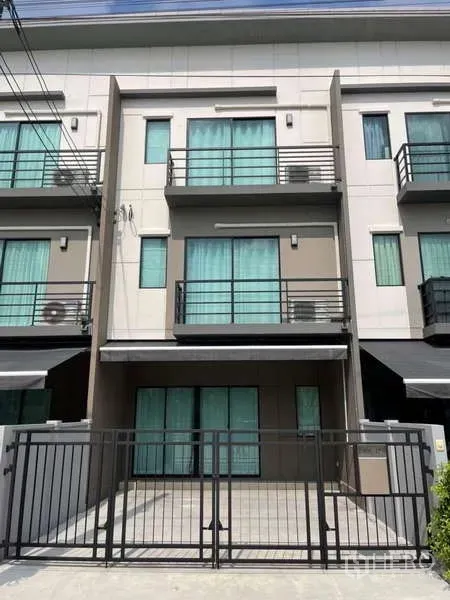 Townhouse for rent or sale in Phasi Charoen, Bangkok - Street view of modern three-story townhouse with front gate and balconies.