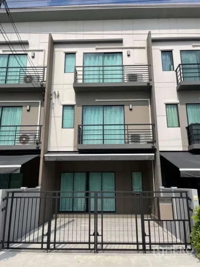 Townhouse for rent or sale in Phasi Charoen, Bangkok - Street view of modern three-story townhouse with front gate and balconies.