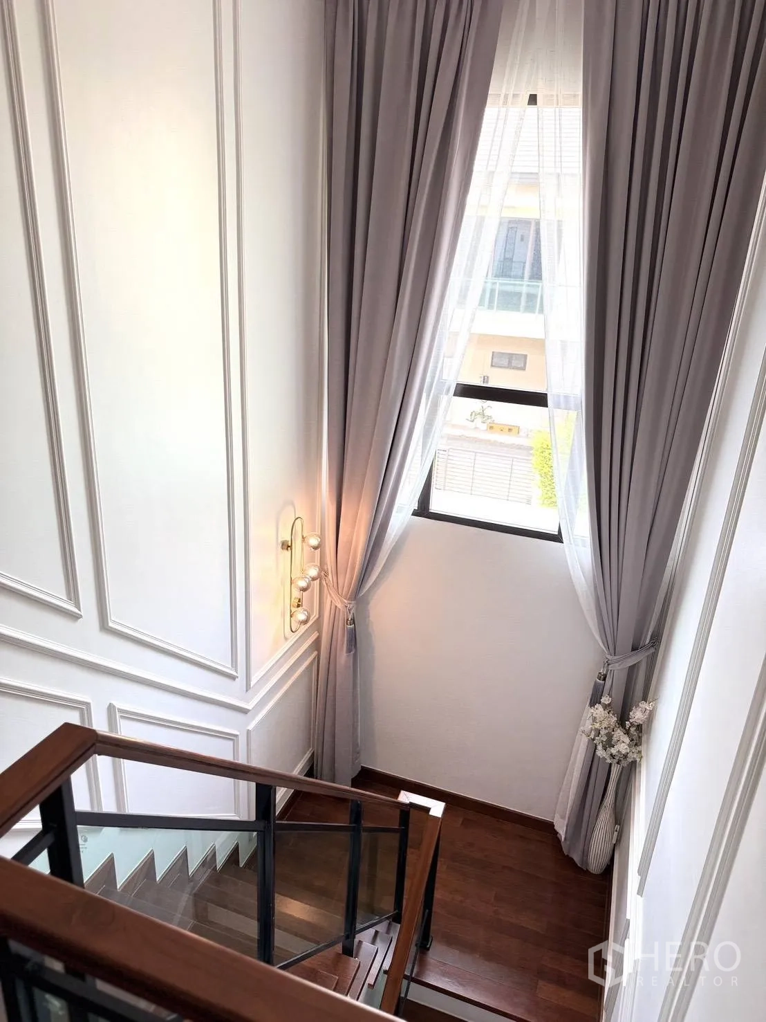 Detached House for rent in Wang Thonglang, Bangkok - Staircase with glass railing and long drapes framing a bright window.