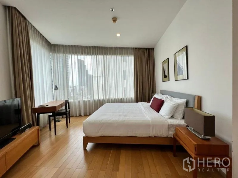 คอนโด ให้เช่าในKhlong Toei, Bangkok - ห้องนอนหลักกว้างพร้อมเตียงขนาดใหญ่ หน้าต่างกระจกเต็มบาน โต๊ะทำงาน และวิวเมือง