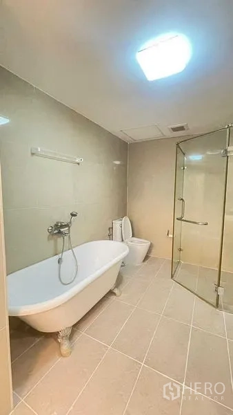 คอนโด ให้เช่าในKhlong San, Bangkok - ห้องน้ำมีอ่างอาบน้ำแบบขาและตู้กระจกอาบน้ำ พื้นกระเบื้อง