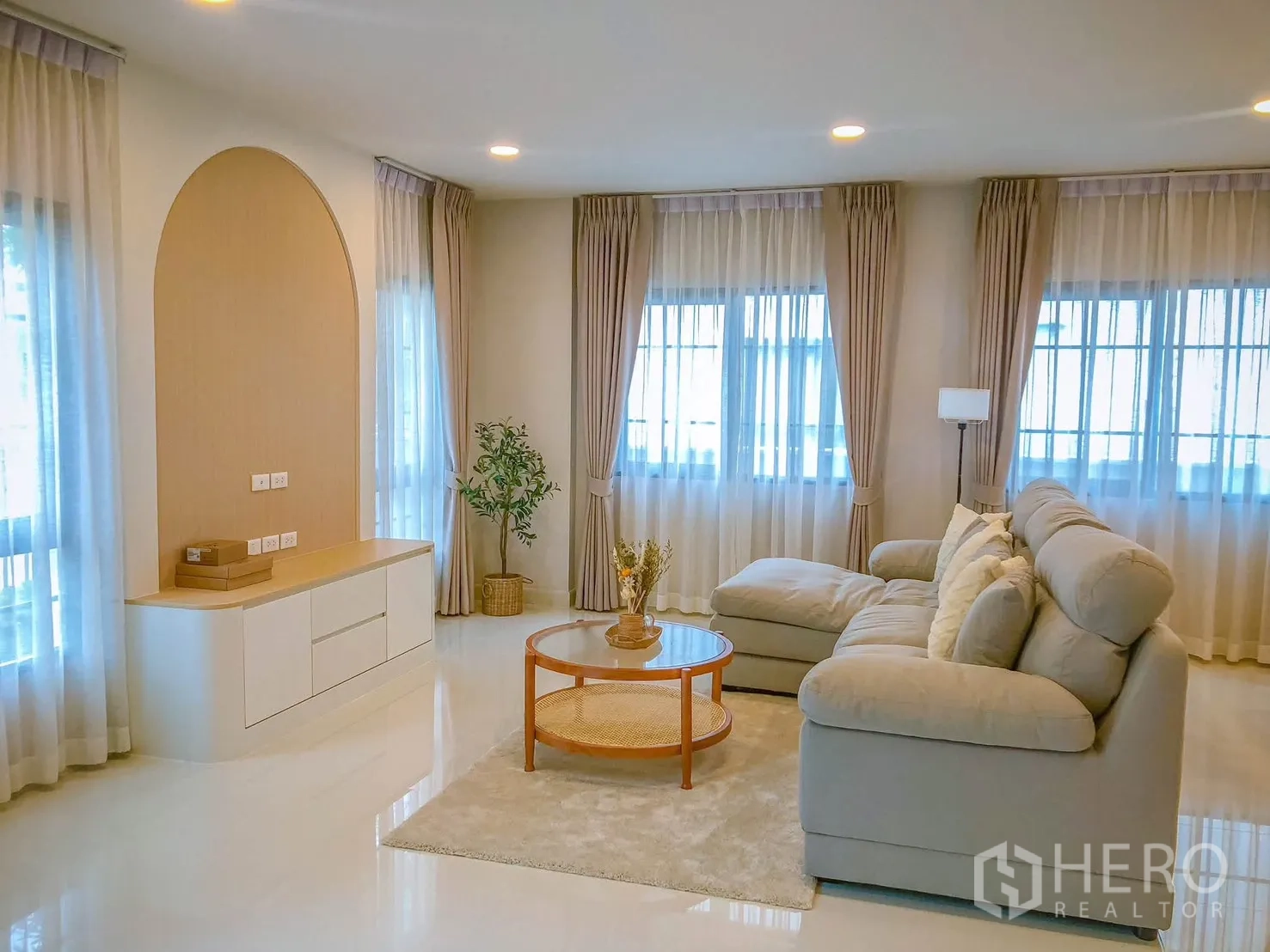 独栋房屋 for rent in Bang Phli, Samut Prakan - 客厅宽敞，超大转角沙发、圆形茶几与多扇窗户。