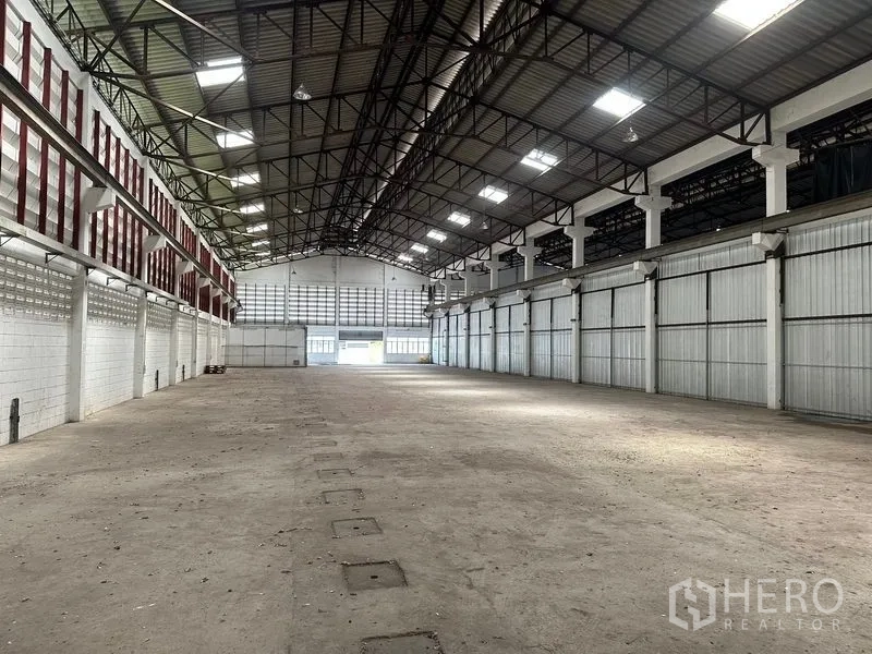 คลังสินค้า ให้เช่าในLam Luk Ka, Pathum Thani - พื้นที่โกดังมุมมองย้อนกลับ พื้นคอนกรีตโล่ง ฝ้าโครงเหล็กสูงพร้อมแผงไฟส่องสว่าง