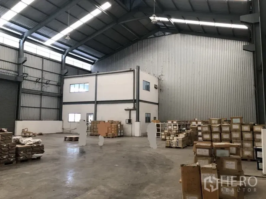 Factory for rent in Khlong Luang, Pathum Thani - Spacious factory warehouse interior with high steel roof, concrete floor and a two-storey office block.