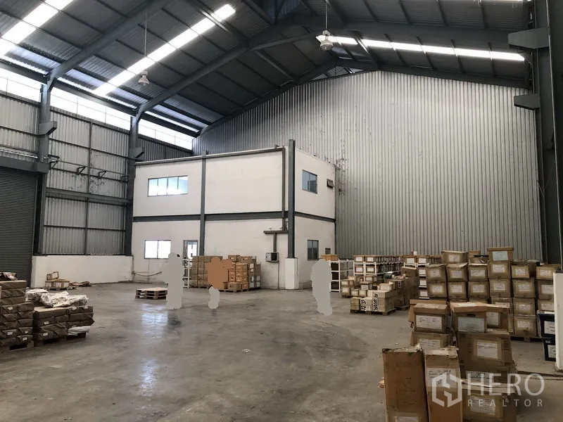 Factory for rent in Khlong Luang, Pathum Thani - Spacious factory warehouse interior with high steel roof, concrete floor and a two-storey office block.