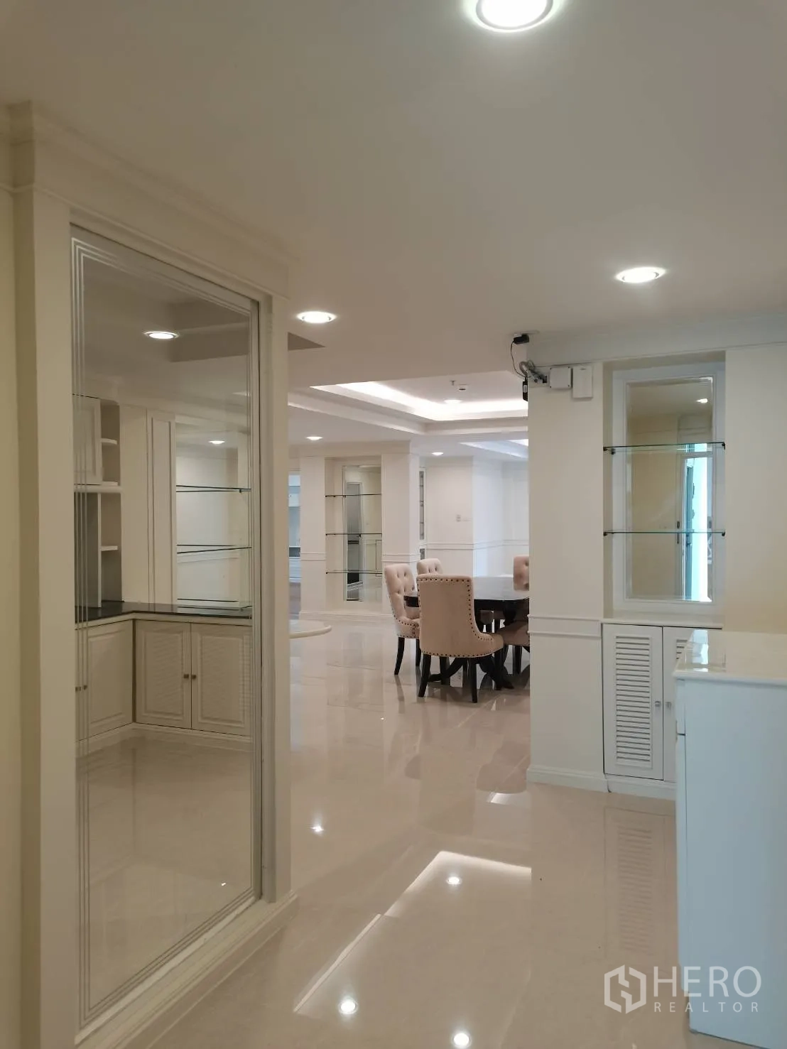 Condominium for rent in Watthana, Bangkok - Wide entry hall with glossy floors, glass display shelves, and a view to the dining area.
