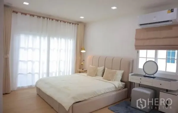Detached House for rent in Bang Phli, Samut Prakan - Bright master bedroom with king bed, vanity and floor-to-ceiling curtains.