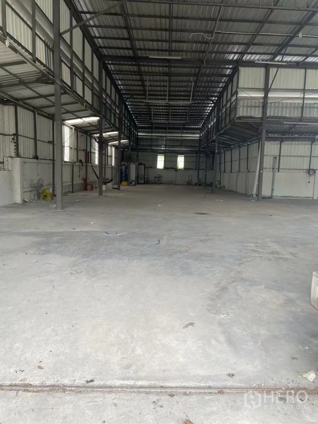 Warehouse for rent in Huai Khwang, Bangkok - Deep view of warehouse showing mezzanine walkways, windows for ventilation and a wide open floor area.