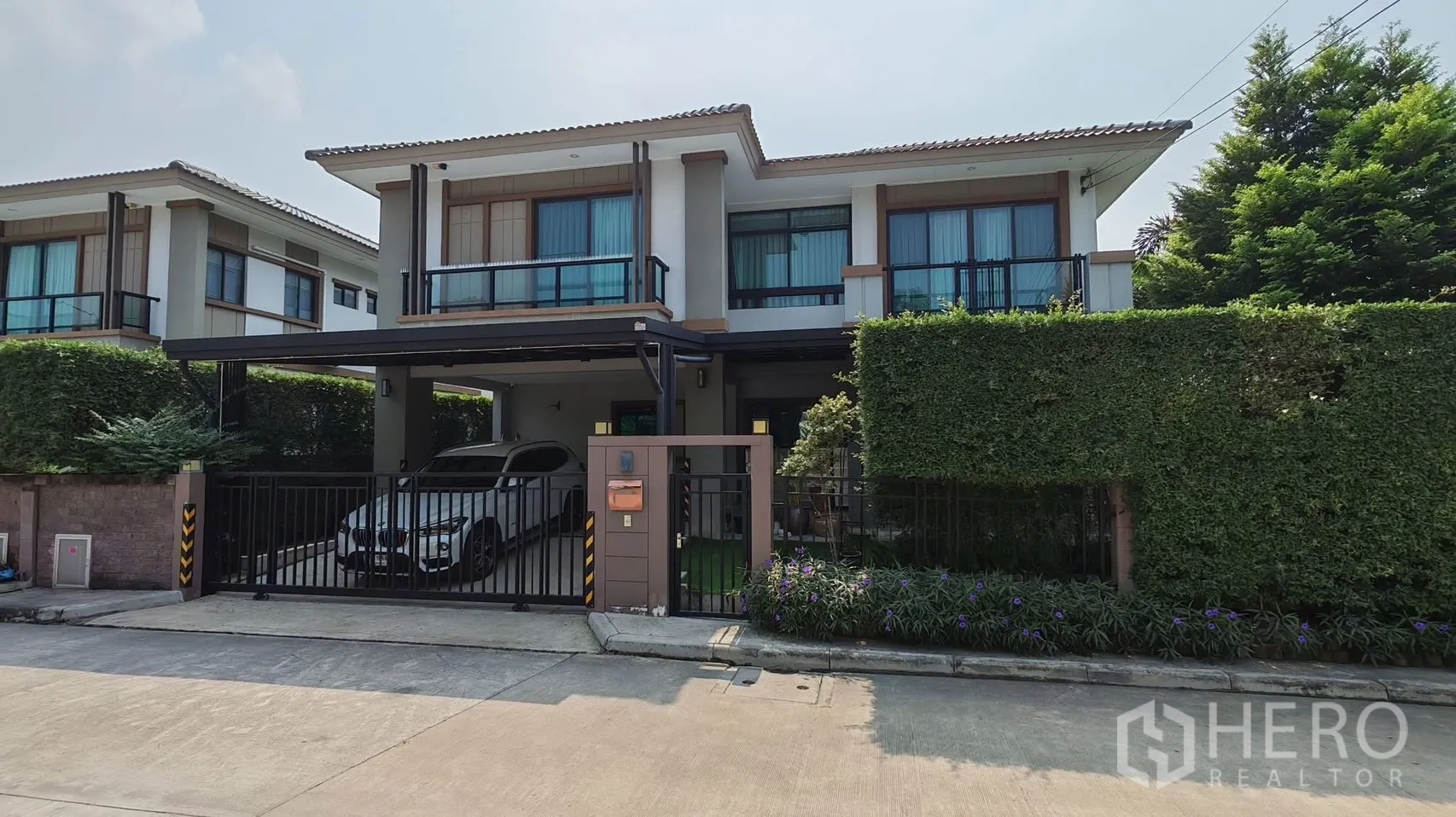 独栋房屋 for rent or sale in Bang Phli, Samut Prakan - 房屋正面带大门与遮雨双车位车棚，绿篱景观。