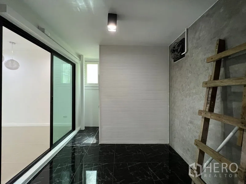 ทาวน์เฮาส์ ขายในBang Kapi, Bangkok - โซนงานเอนกประสงค์ด้านหลัง พื้นกระเบื้องดำ ผนังกระจกบานเลื่อน