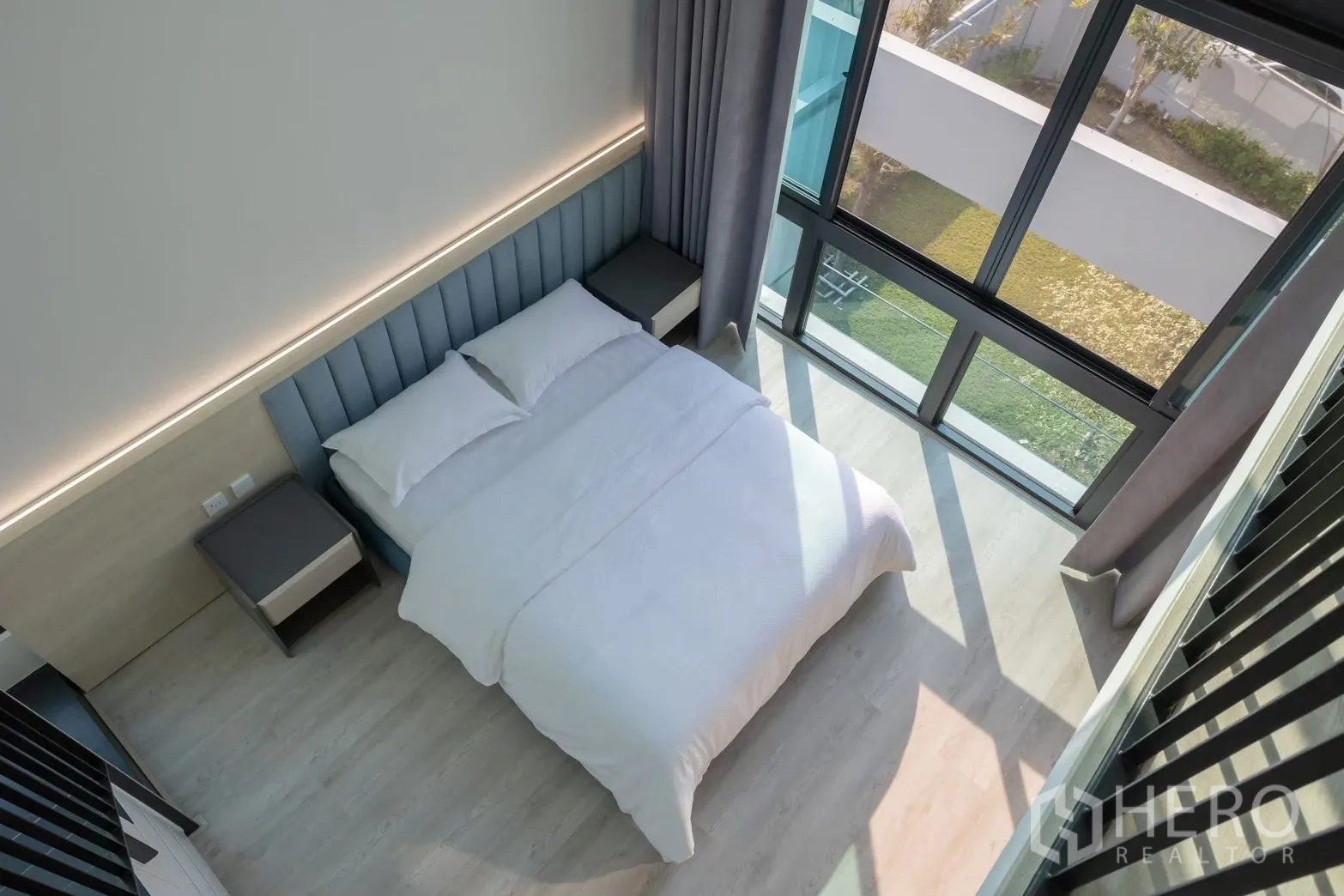 Detached House for rent in Saphan Sung, Bangkok - Aerial view of a double-height bedroom with full-height windows and queen bed.