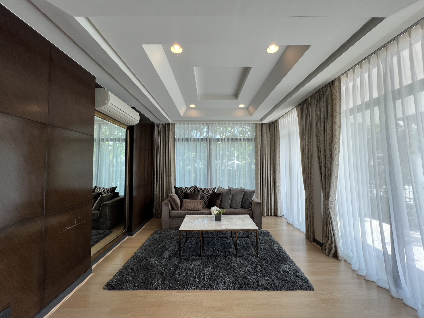 Detached House for rent in Bang Kapi, Bangkok - Bright living room with coffered ceiling, sheer curtains and a sofa set.