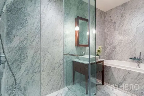 公寓 出租在Watthana, Bangkok - 全大理石浴室，玻璃淋浴间、浴缸与吊灯上方的洗手台。