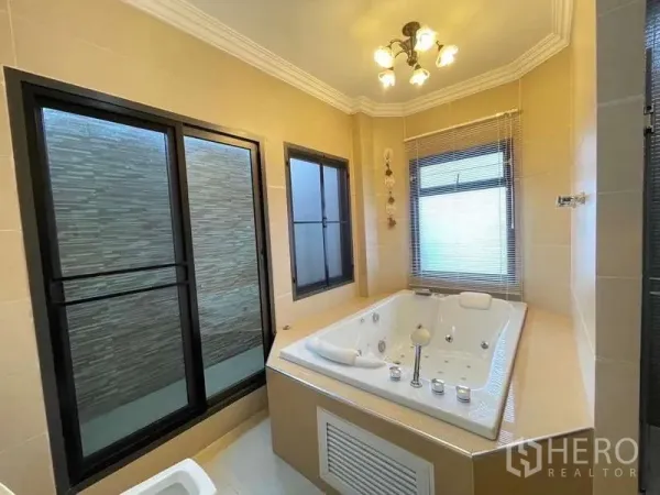 独立式住宅 出租在Mueang Nonthaburi, Nonthaburi - 转角处配按摩浴缸，临窗设计与暖色顶灯。