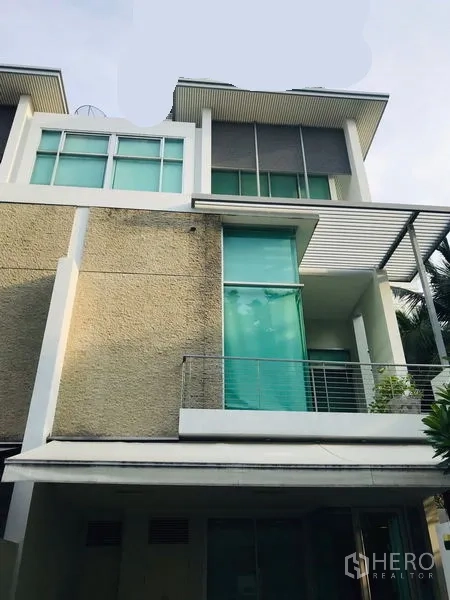 ทาวน์เฮาส์ ให้เช่าหรือขายในChatuchak, Bangkok - ด้านหน้าทาวน์เฮ้าส์ร่วมสมัยมีระเบียง กระจกสูง และผนังเท็กซ์เจอร์