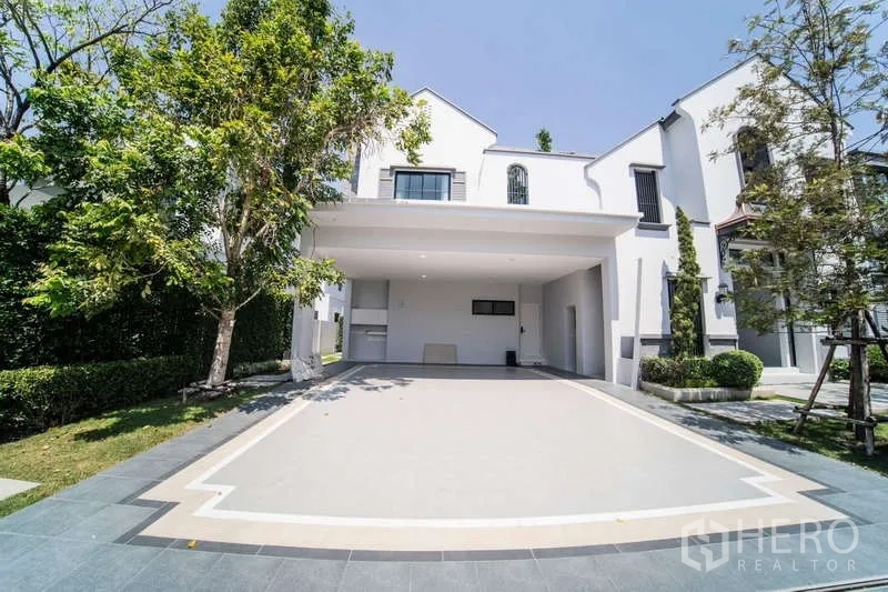 บ้าน ให้เช่าในSaphan Sung, Bangkok - ที่จอดรถในร่มรองรับสองคัน พร้อมลานหน้าบ้านกว้างและต้นไม้ร่มรื่น