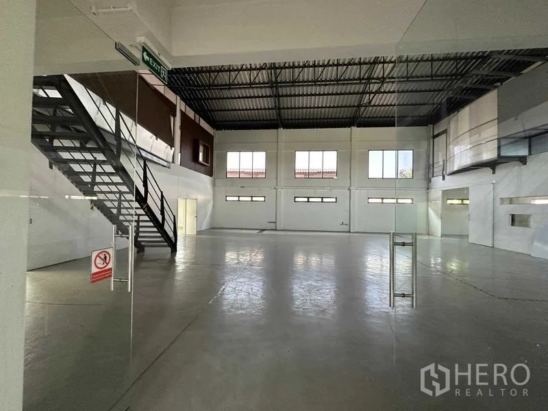 คลังสินค้า ให้เช่าในPhra Khanong, Bangkok - พื้นที่เก็บของชั้นล่างพร้อมบันไดเหล็กและพื้นคอนกรีตเรียบ