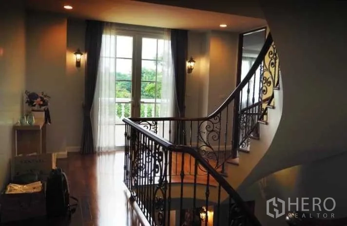 บ้าน ขายในPhra Khanong, Bangkok - โถงบันไดพร้อมราวเหล็กดัด ประตูกระจกแบบฝรั่งเศส และวิวสีเขียวจากระเบียง