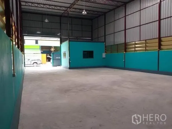 Warehouse for rent in Nonthaburi - Open-plan warehouse floor facing the front gate, showing the internal office room and loading access.