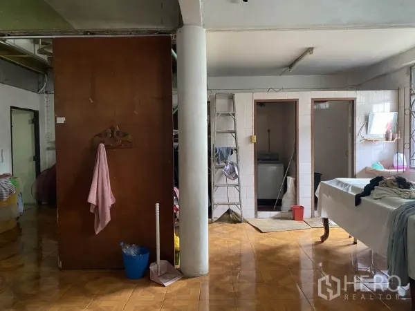 店屋 出租在Khlong Toei, Bangkok - 铺有瓷砖的多功能房，带立柱、杂物间门与清洁工具。