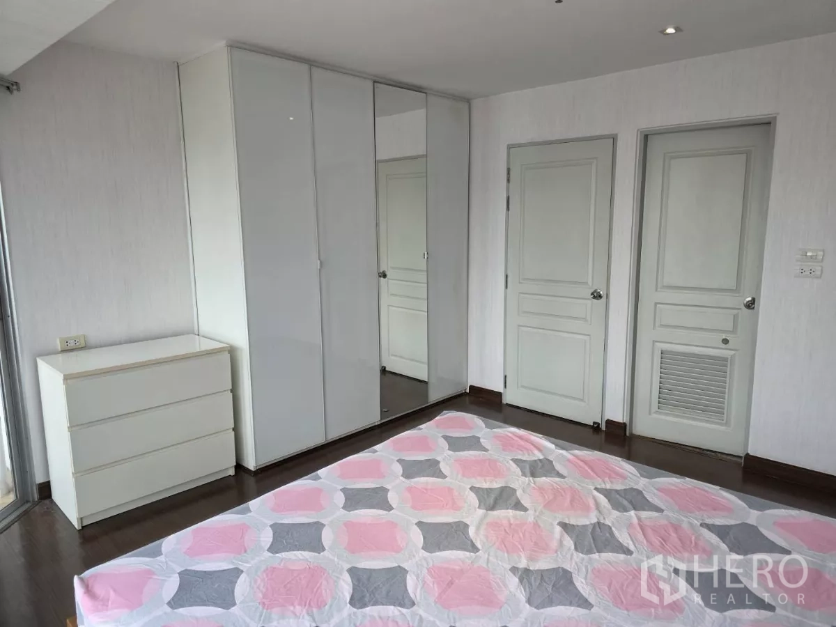 คอนโด ให้เช่าในKhlong Toei, Bangkok - ห้องนอนพร้อมตู้เสื้อผ้าบิวท์อิน ลิ้นชัก และโทนสว่างเรียบง่ายข้างประตูสองบาน