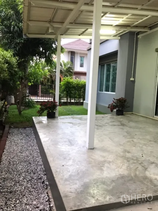 Detached House for rent in Saphan Sung, Bangkok - Covered terrace beside a small side garden and gravel path.