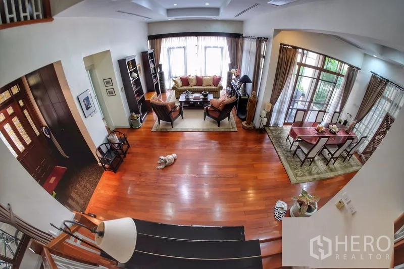 บ้าน ให้เช่าในWatthana, Bangkok - มุมมองจากบันไดสู่โถงรับแขกและรับประทานอาหาร พื้นไม้และหน้าต่างกว้าง