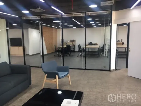 Office Space for rent in Sathon, Bangkok - Reception lounge with sofa and armchair facing glass-partitioned meeting rooms under modern lighting.