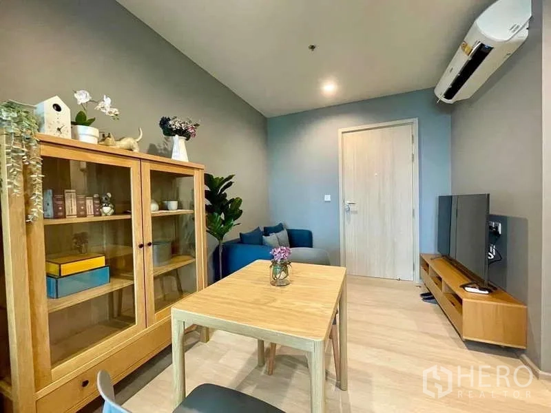 Condominium for rent in Pathum Wan, Bangkok - Bright living and dining area with wooden furniture, TV console and air-conditioning in a modern Bangkok condo