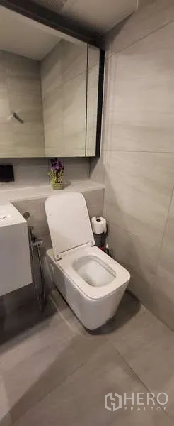 Condominium for rent - Modern bathroom with wall-mounted vanity, mirror cabinet, and toilet.
