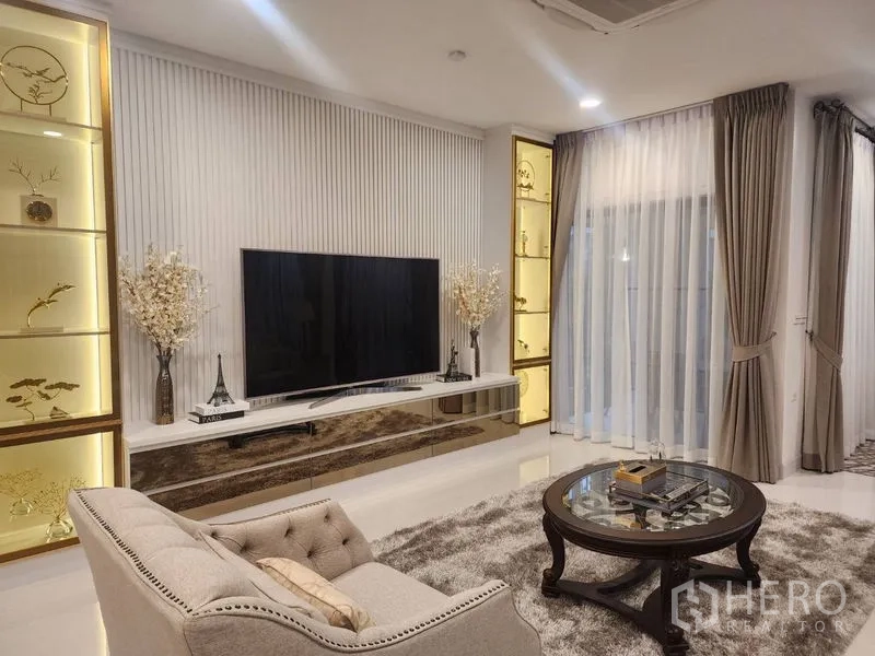 Detached House for rent or sale - Living room featuring illuminated display cabinets and a large TV wall