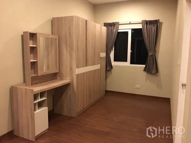 Detached House for rent or sale in Bang Na, Bangkok - Cozy bedroom featuring a wardrobe and dressing table beside the window.