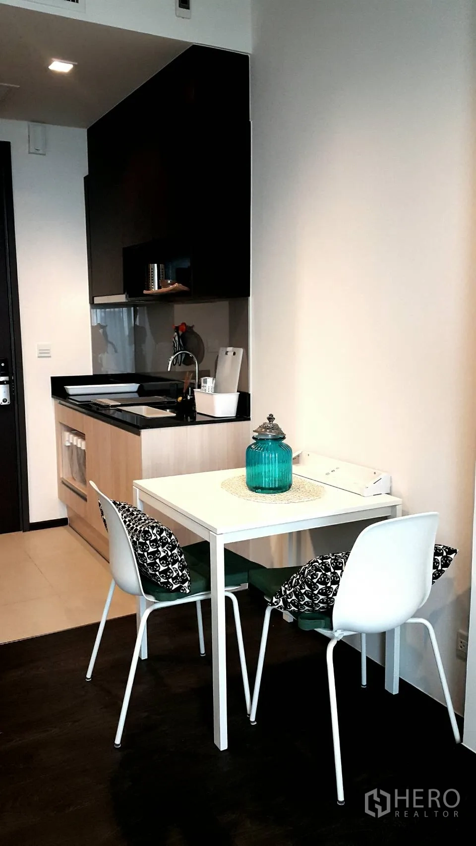 Condominium for rent in Watthana, Bangkok - Compact kitchenette with black countertop and a two‑seat dining table in a modern condo.