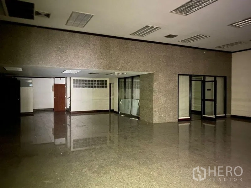 零售空间 出租 - 大型大厅，抛光石材地面与玻璃隔间、吊顶照明。