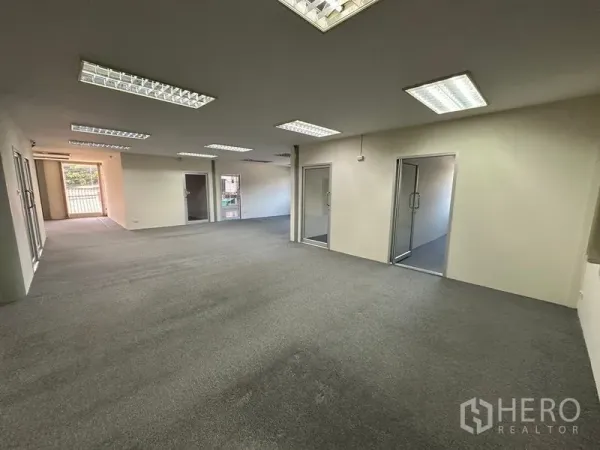 Office Space for rent - Open workspace with glass-partitioned rooms and natural light.