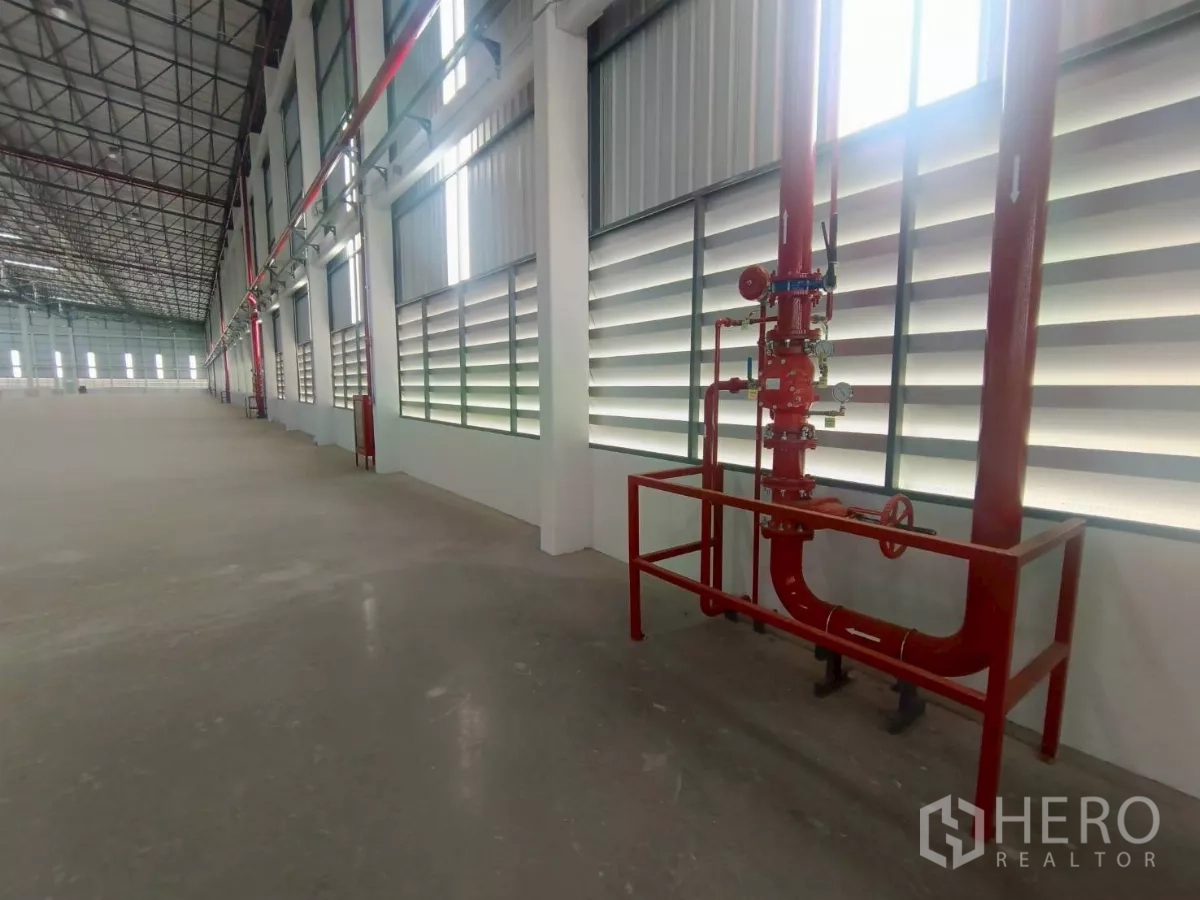 Factory for rent in Si Racha, Chon Buri - Fire protection piping and sprinkler riser installed along the warehouse wall.